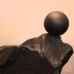 MODERN OBJECT IN BLACK STONE WITH A BALL ON TOP